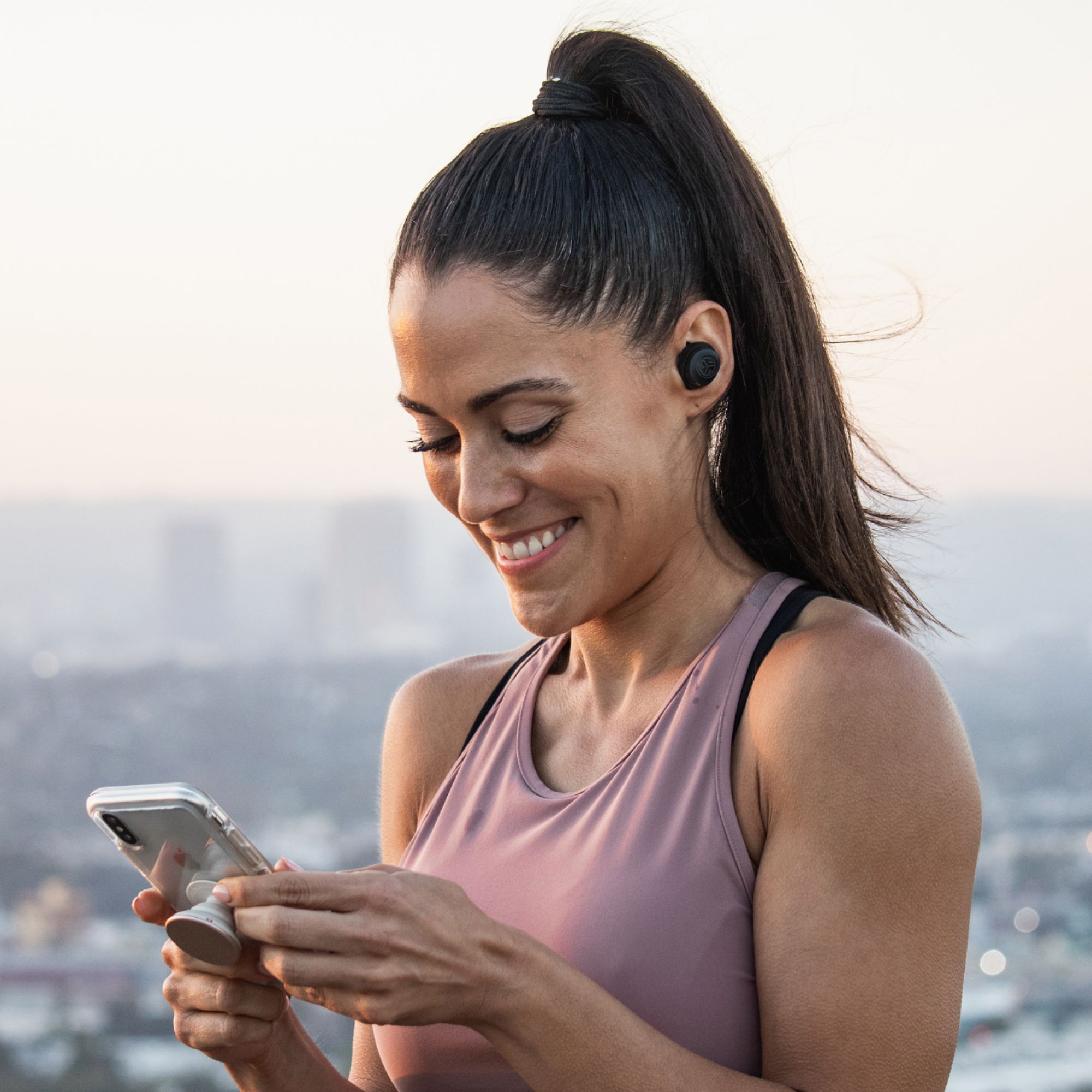 A woman using JLab wireless headphones