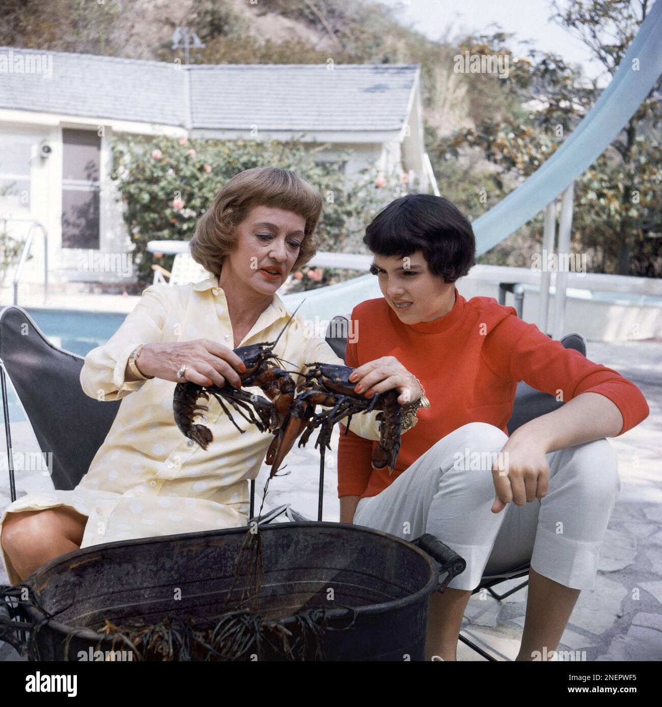 Film actress Bette Davis is shown with her 13yearold daughter Margot Merrill, poolside at