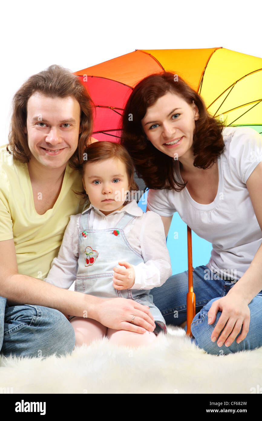 Happy young family mother, father and little daughter are sitting