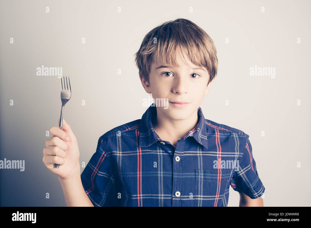 little boy with fork ready to eat filtered retro style Stock Photo