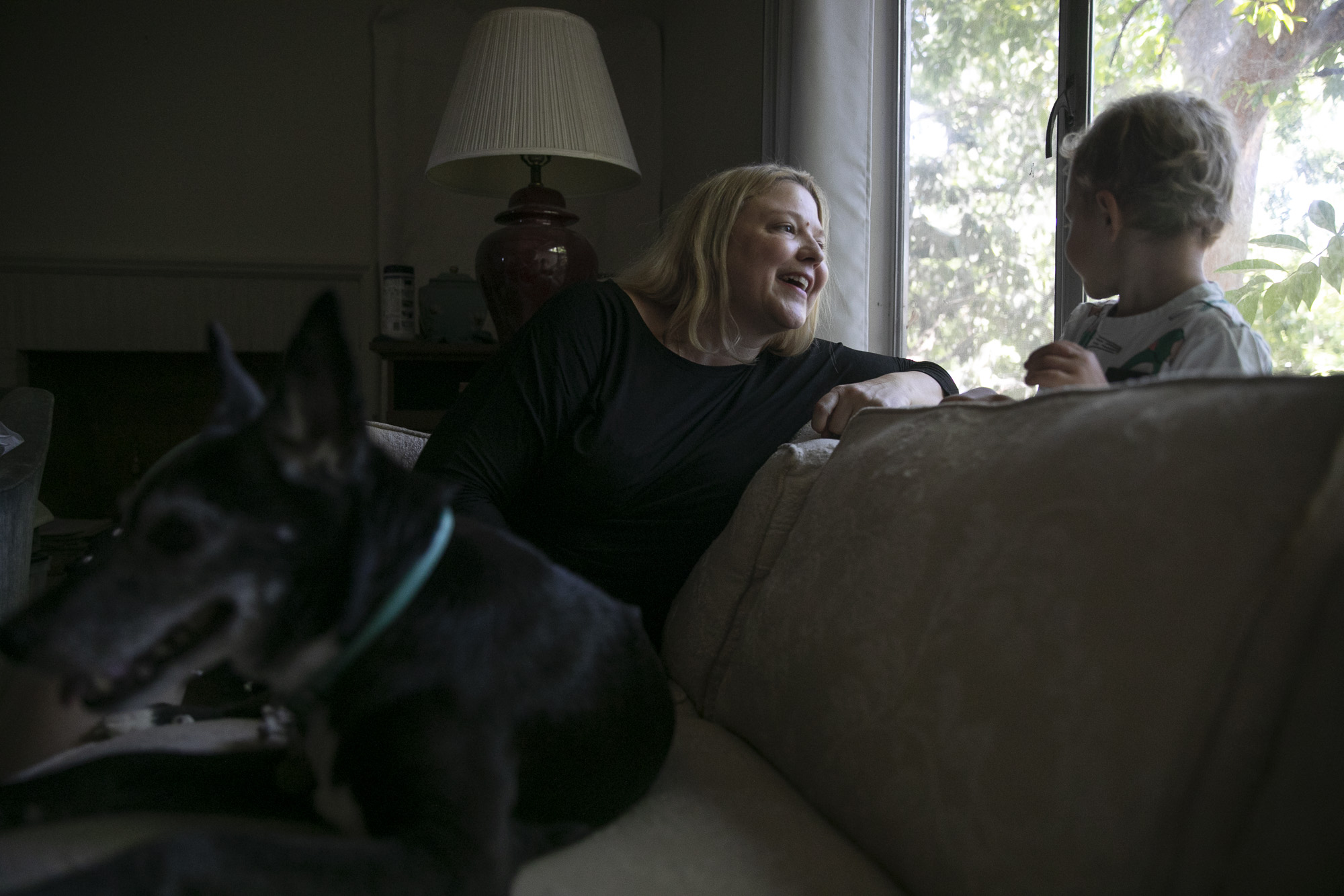Elizabeth Olson and her son Lucas, 2, sit in the living room of their newly-purchased home in the Land Park neighborhood of Sacramento on Aug. 4. 2021. Olson hopes to renovate the house into a duplex so to make room for her aunt and her partner, who currently live in the home. Photo by Anne Wernikoff, CalMatters