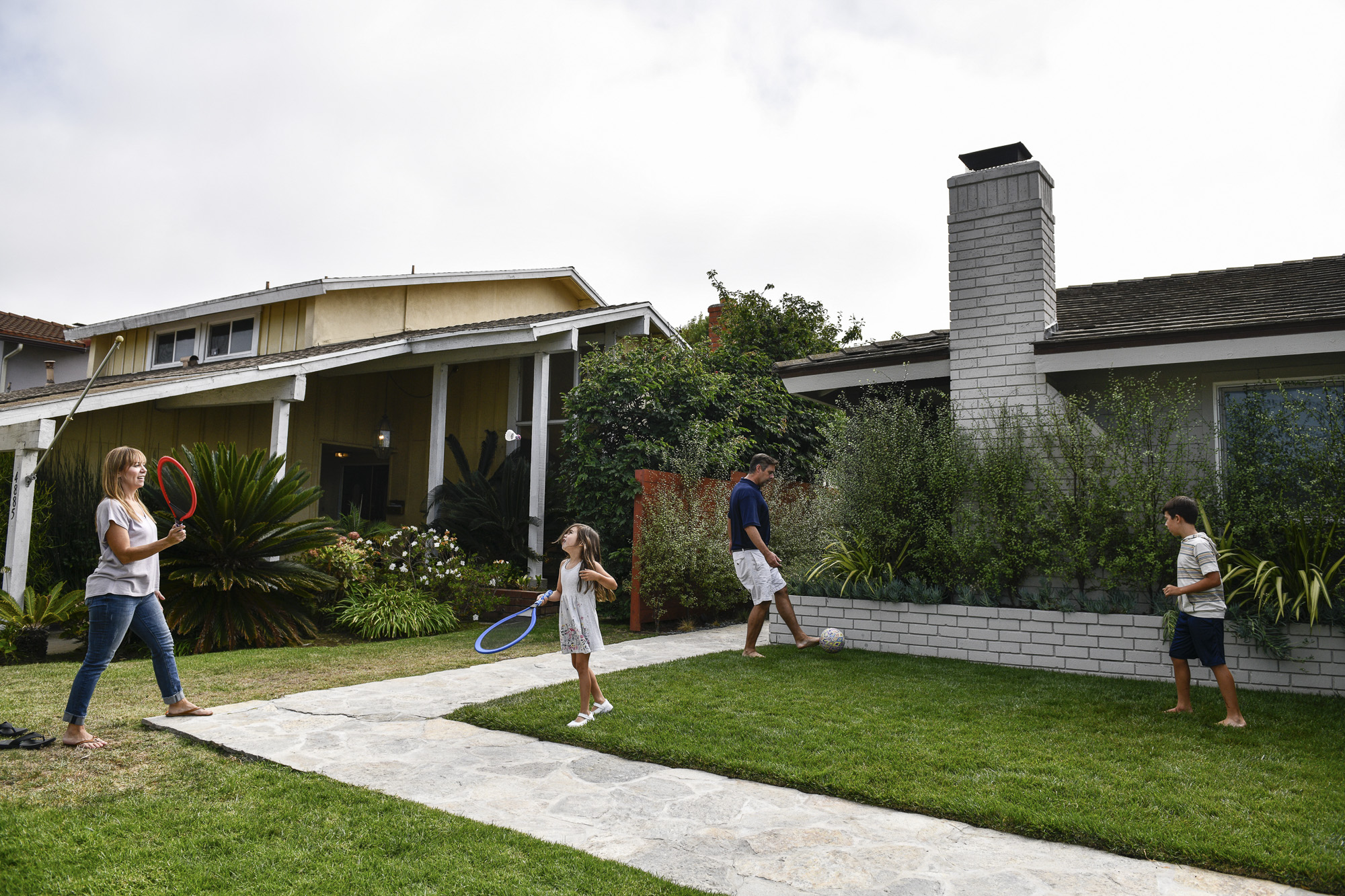 Cynthia Rojas and Kevin Jardim play with their kids in the front yard of their Culver City home. According to the couple, if the Newsom recall doesn't succeed, they may move to another state.
