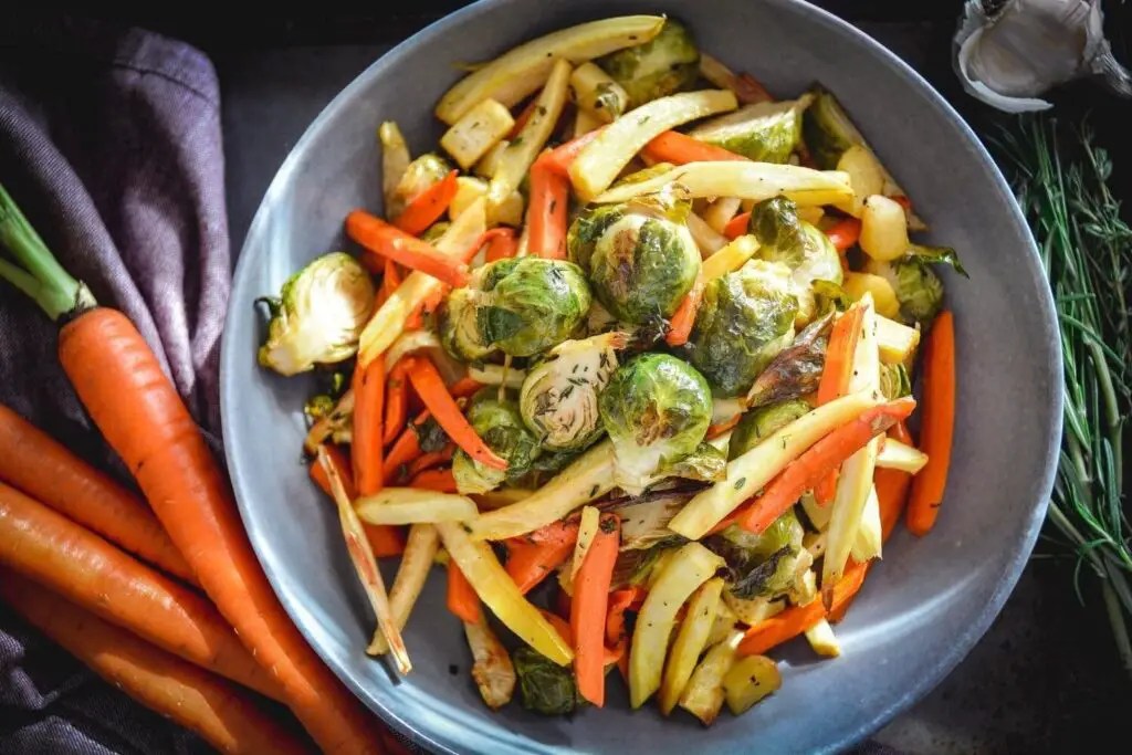 Roasted root vegetables on plate with carrots, herbs and napkin
