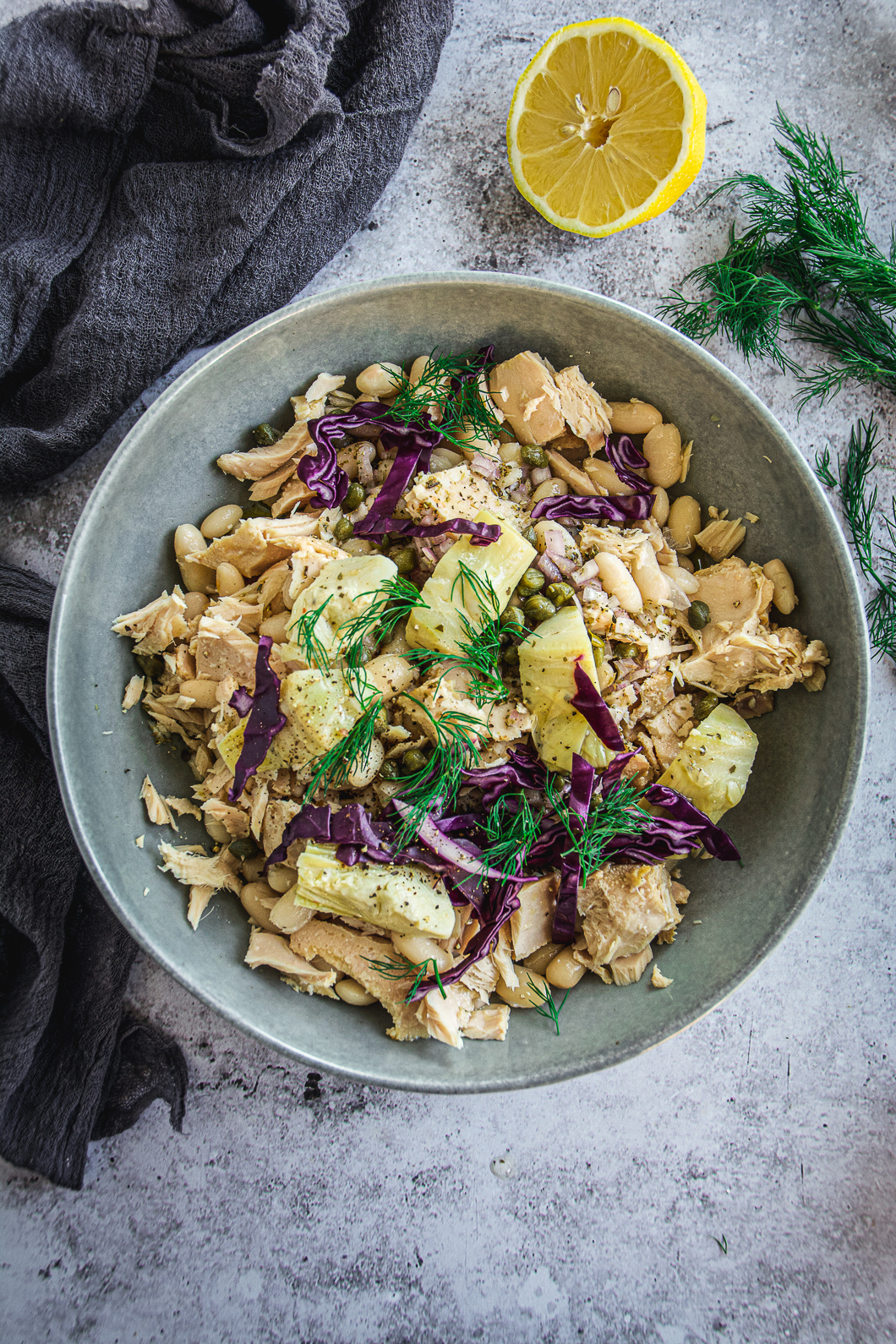 White Bean salad with tuna capers and artichoke hearts in bowl