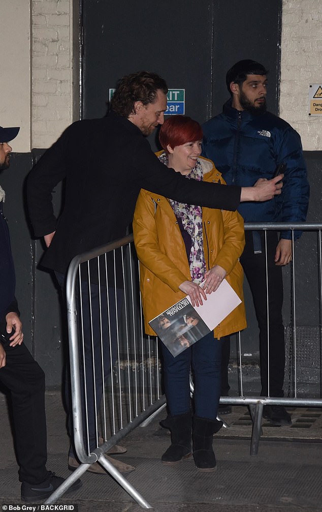 Tom Hiddleston looks in high spirits as he poses for selfies with fans