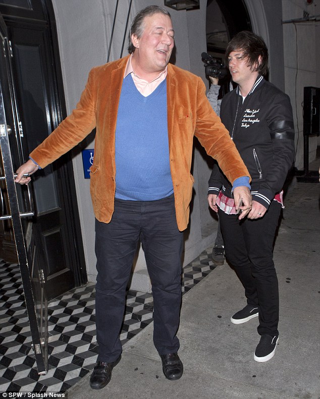 Stephen Fry beams as he steps out for dinner with husband Elliott