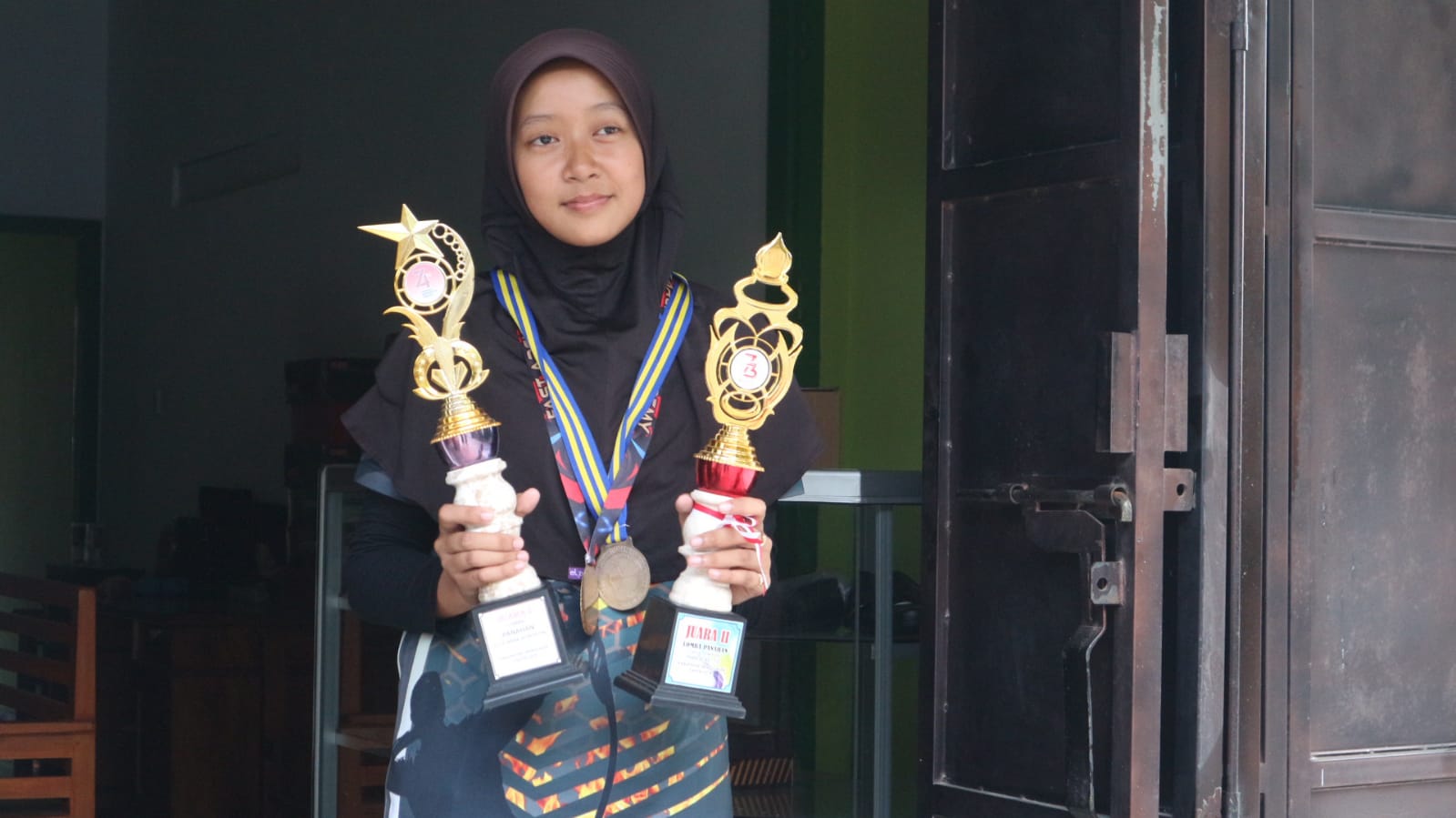Kegigihan Erisa, Pemanah Perempuan dari Trenggalek Bermodal Busur Bambu 1 Erisa memegang piala juara memanah