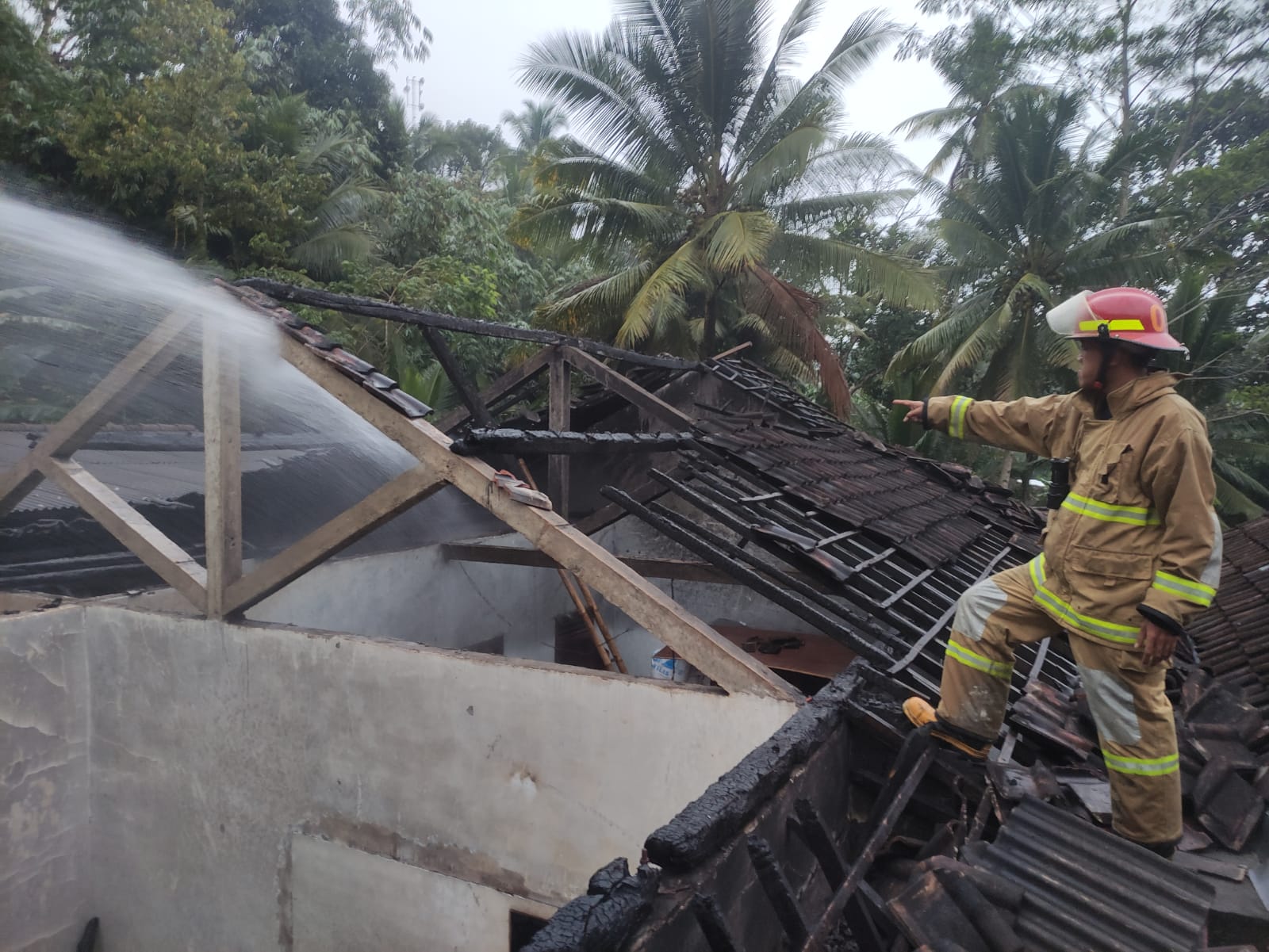 Detik Detik Mobil dan Rumah Warga di Watulimo Terbakar 3 Proses pemadaman api di atap rumah