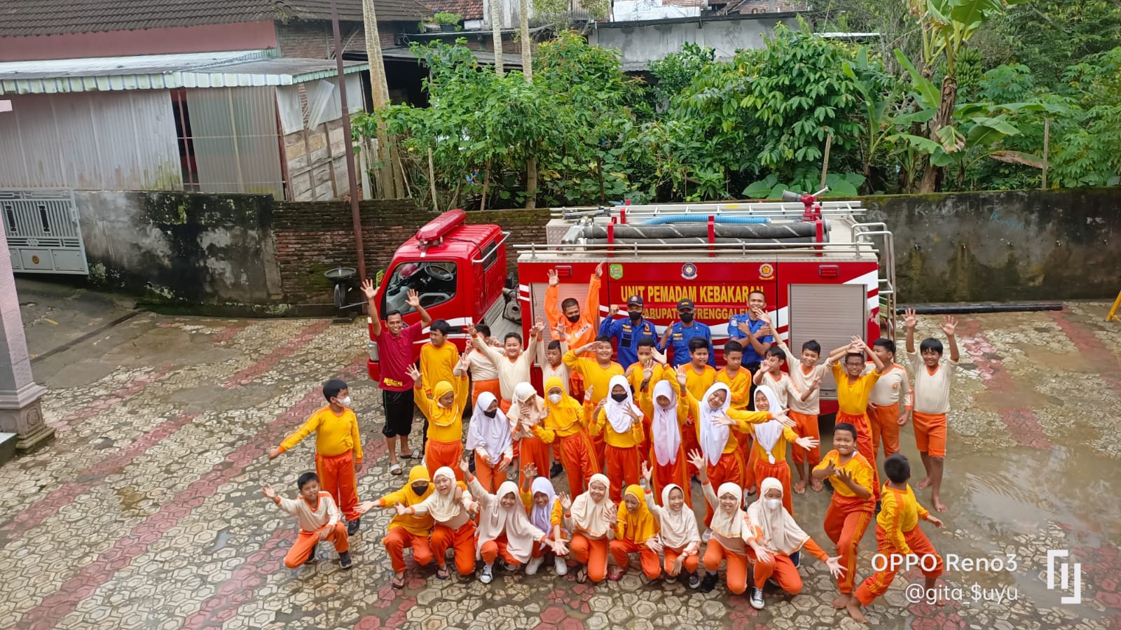 Damkar Trenggalek Bersihkan Sisa Lumpur Banjir di Halaman MI Muhammadiyah Watulimo 1 Pelajar MI Muhammadiyah Watulimo berfoto dengan petugas