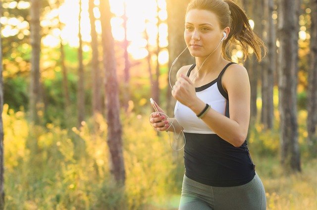 Tips Bangun Pagi untuk Kamu yang Sering Bangun Kesiangan sampai Telat Masuk Kantor 3 Seorang perempuan sedang olahraga lari lari di hutan