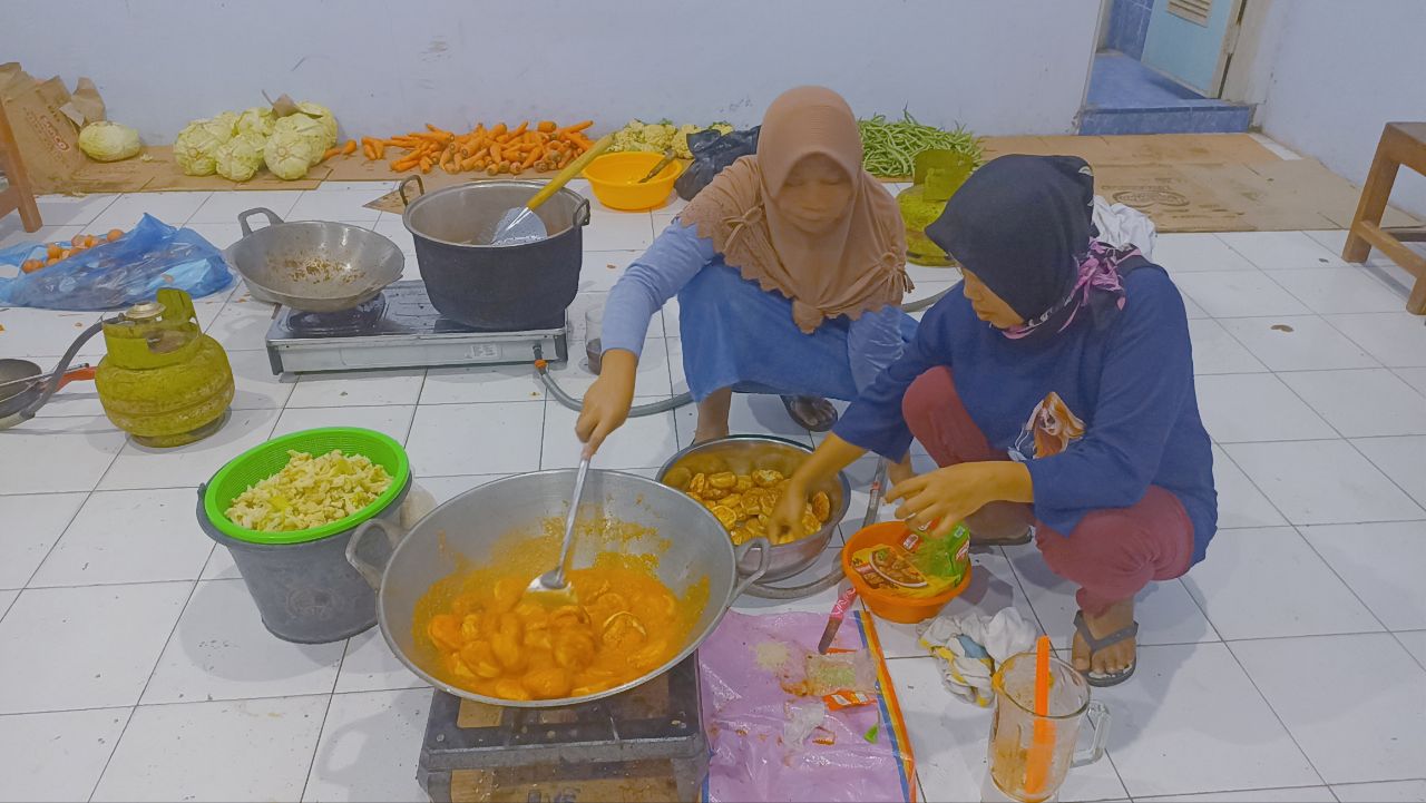 Suasana Terkini Dapur Umum SMK Muhammadiyah Watulimo untuk Bantu Kebutuhan Makan Korban Banjir 3 Supiyah dan Nyami sedang memasak telur balado