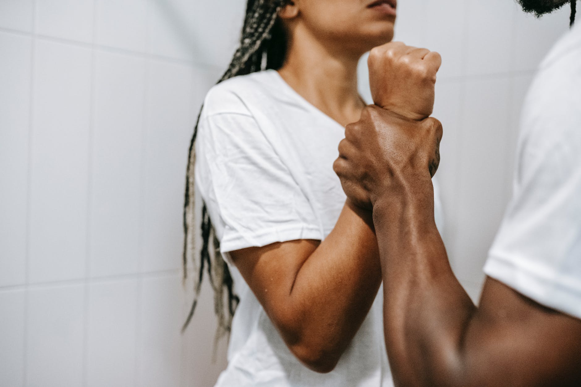 faceless muscular ethnic man grabbing wrist of girlfriend during dispute