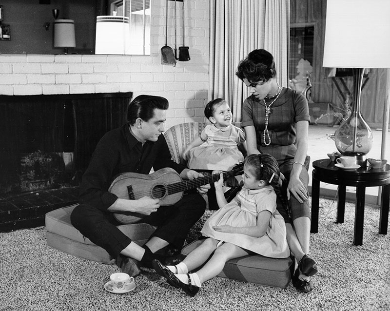 Country singer/songwriter Johnny Cash holds a guitar as his wife Vivian