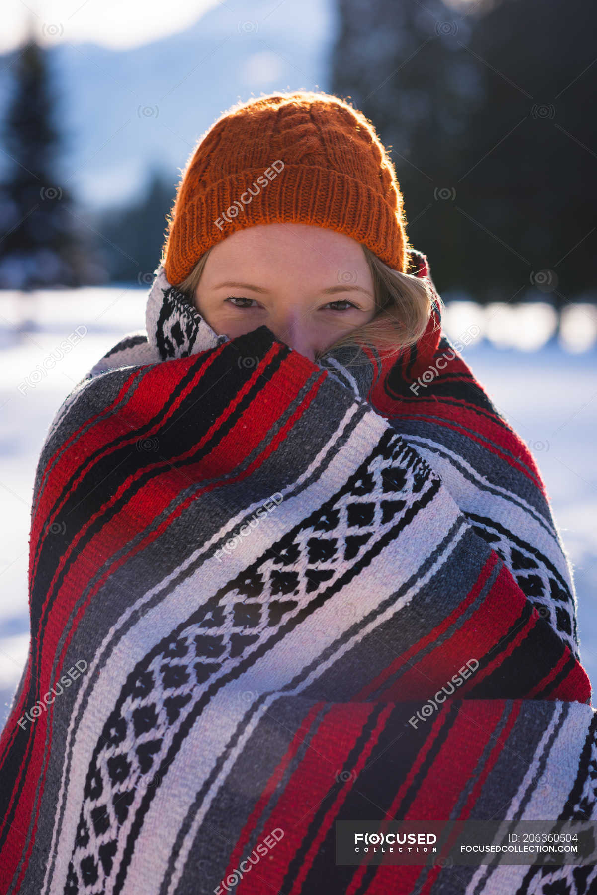 Smiling woman wrapped in blanket in snow — one person, travel