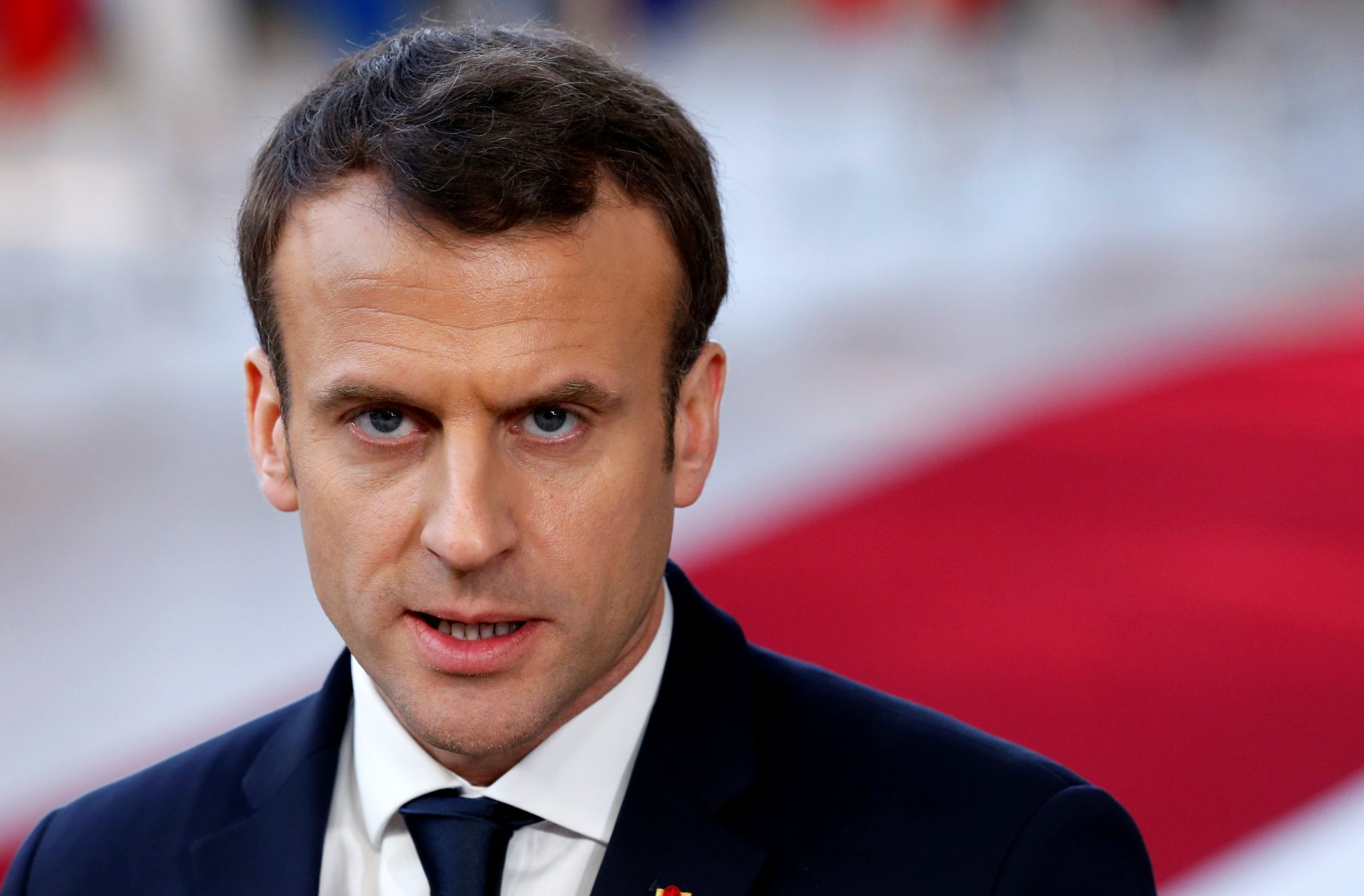 French President Emmanuel Macron briefs the media as he arrives at a