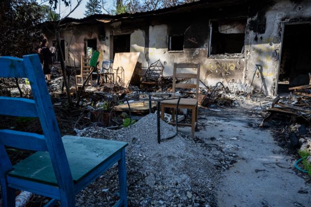 Chairs sit beside piles of burned debris sifted to find human remains, as Israeli residents of the Nir Oz kibbutz grapple with being overrun by Palestinian Hamas militants from the nearby Gaza Strip on 6 December 2023