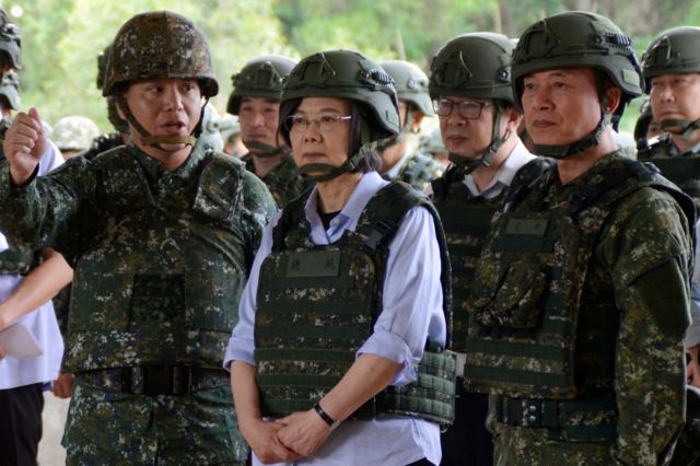 Taiwan president Tsai Ing-wen wearing a military vest standing among military officials at a reservist base in Taoyuan