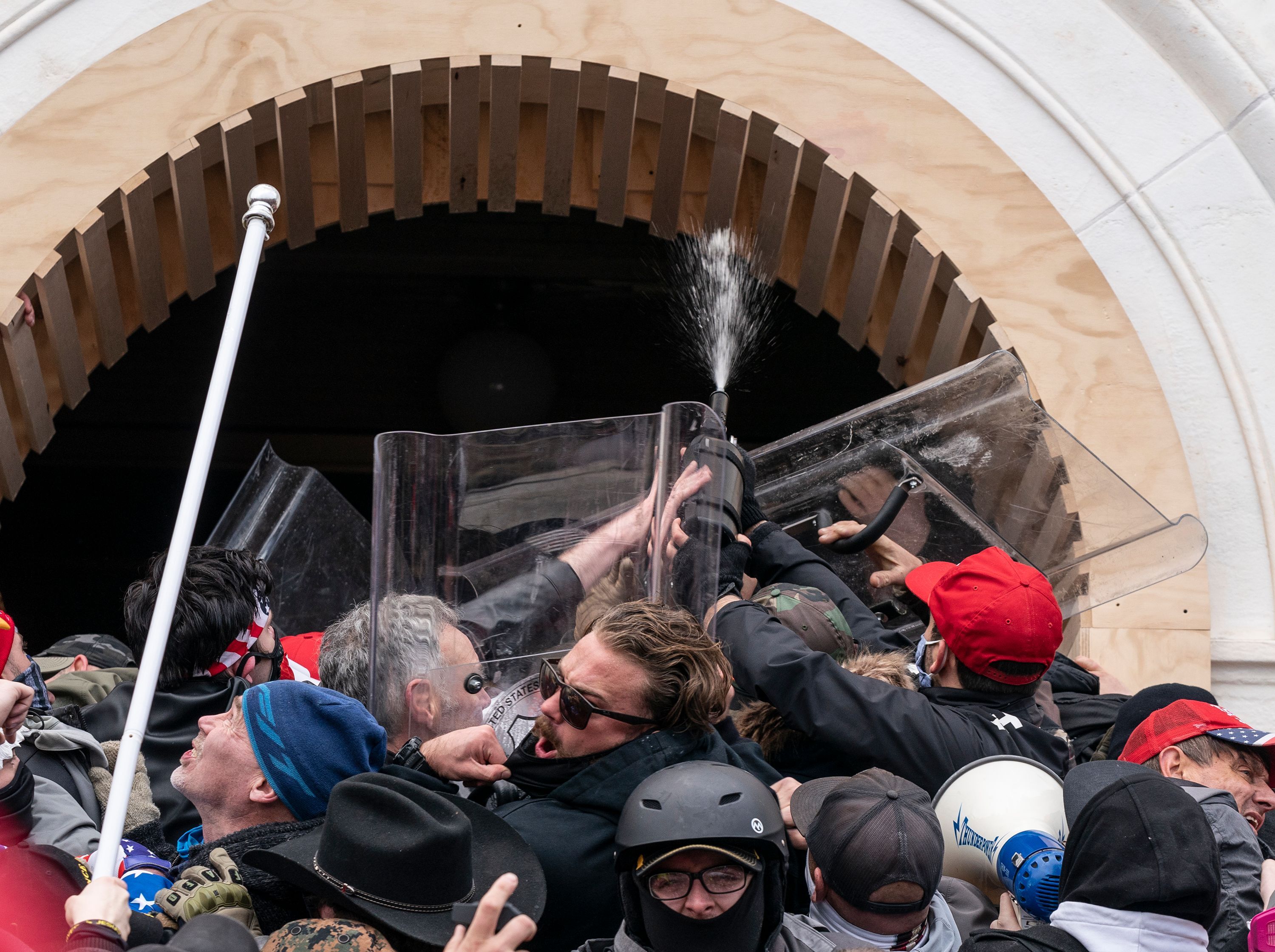 Pro-Trump protesters use tear gas against police as they try to enter the U.S. Capitol building through front doors on Jan. 6, 2021. Fischer is at the center of the melee wearing sunglasses.