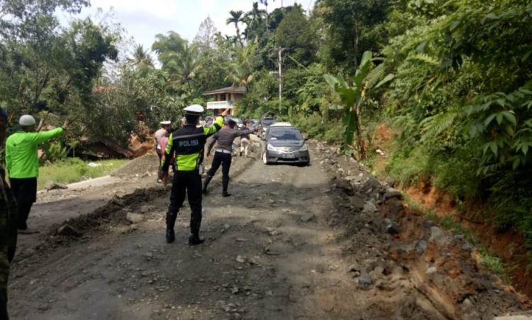 Polisi mengatur lalu lintas di jalur Sumbar-Riau yang amblas