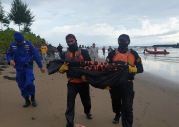 Personel Basarnas mengevakuasi jasad korban yang terseret ombak di Kelurahan Bungo Pasang, Kecamatan Koto Tangah, Kota Padang. (foto: Basarnas Padang)