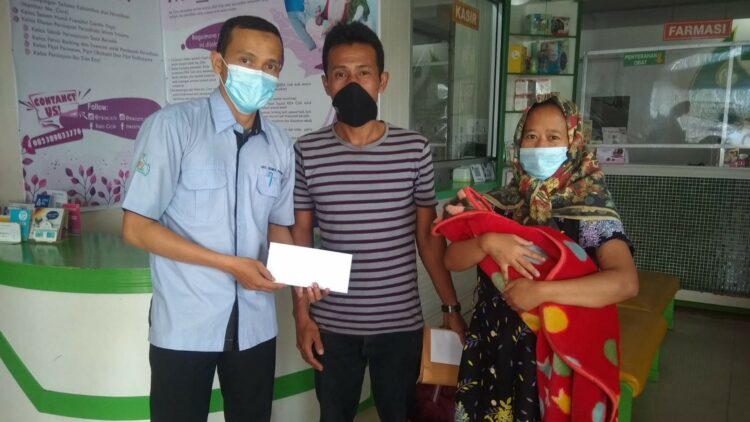Staf UPZ Baznas Semen Padang Antoni Saputra (kiri) menyerahkan bantuan program kesehatan kepada penerima manfaat yang sedang berutang biaya pengobatan di sebuah RS, beberapa waktu lalu. (Foto: dok humas SP)