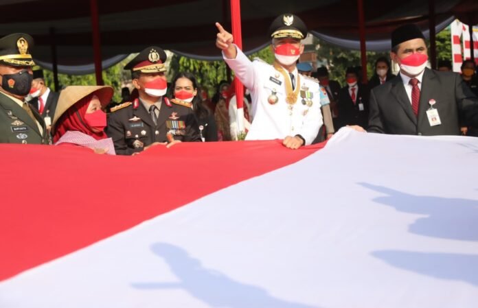 BENDERA. Buruh migran yang memberikan bendera merah putih ukuran besar kepada Ganjar Pranowo.