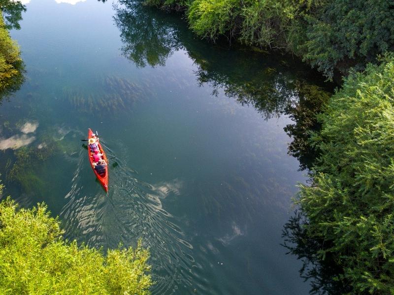 aerial shot of red canoe with a family paddling on a Norfolk river 