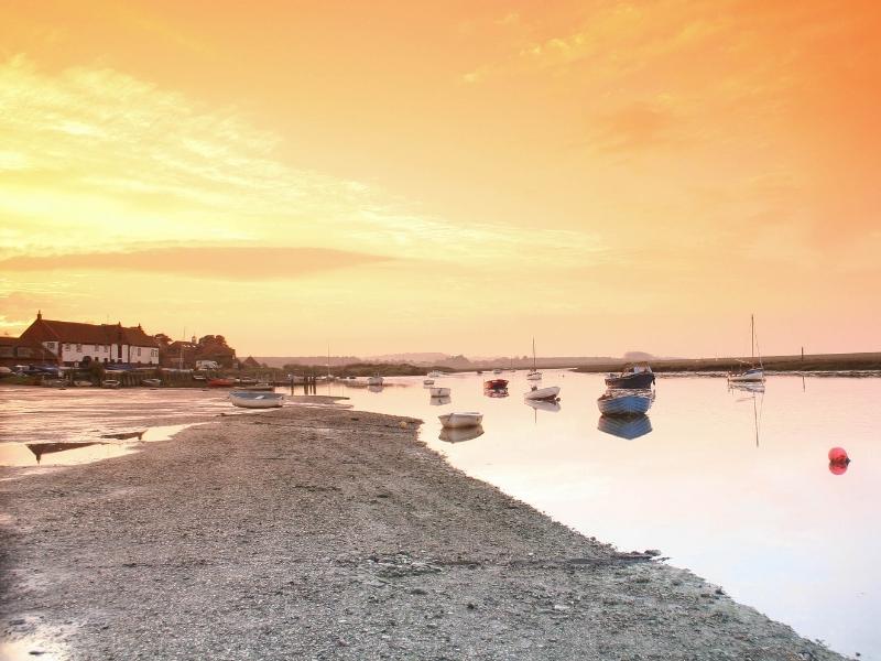 Boats moored at Burnham Overy Staithe at sunset
