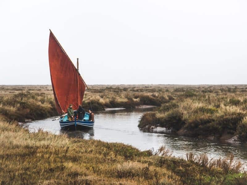 Norfolk crab boat with red sail, sailing on the creeks of the North Norfolk coast