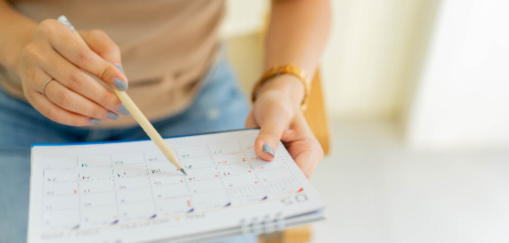 person writing on calendar