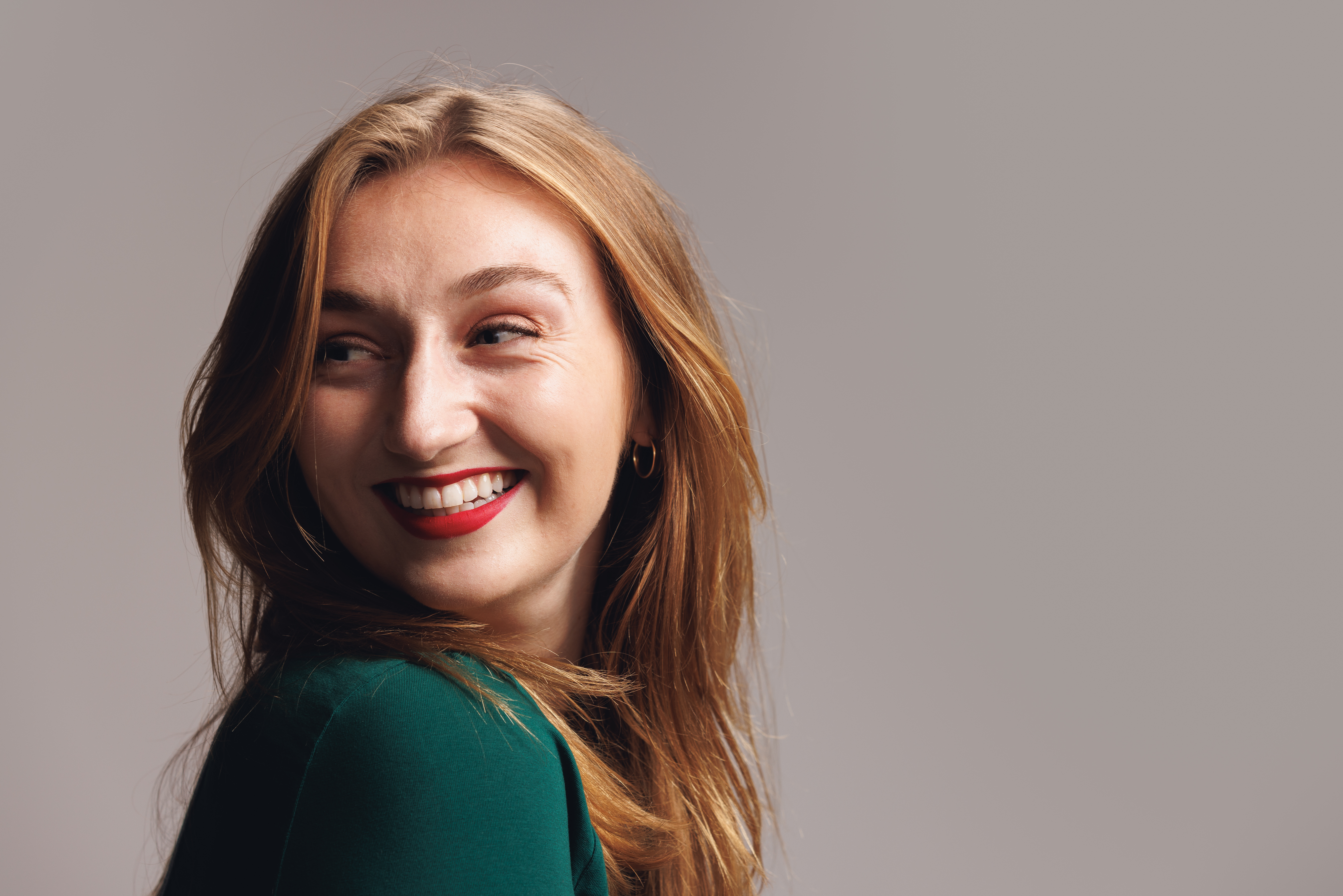 Image of a student smiling over her shoulder 