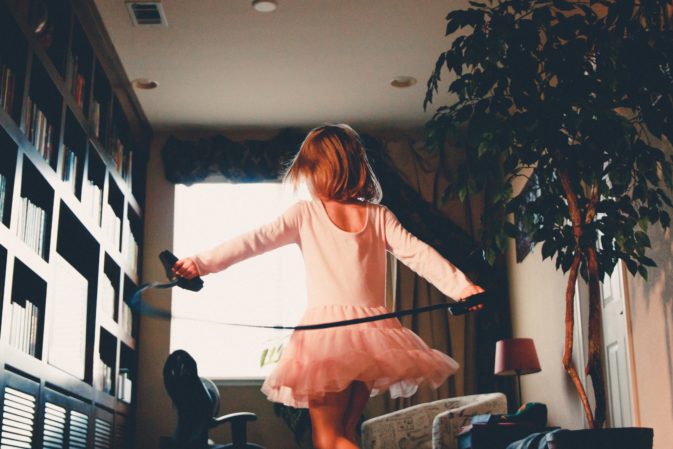 little girl in tut spinning around a room - as illustrating an article on overwhelm with an ADHD child