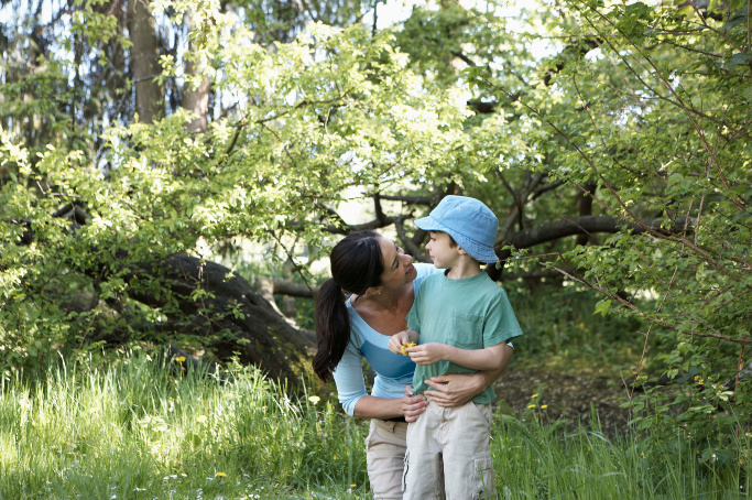 mom and son out in nature - mom is hugging son as if to reassure him and helping him to use a calm down technique 