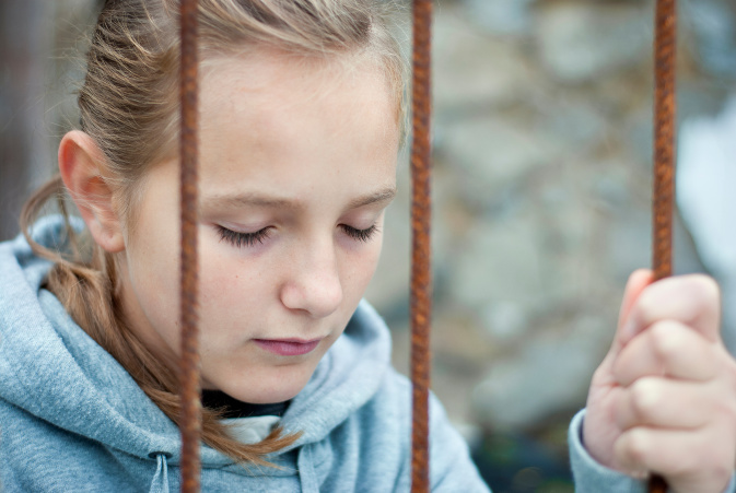 girl with eyes closed, holding onto a piece of rope - illustrating calming techniques for kids