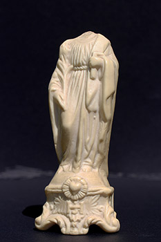 Small broken white statue of St. Joseph. Head of the statue is missing; a carpenter’s square in his left hand.      