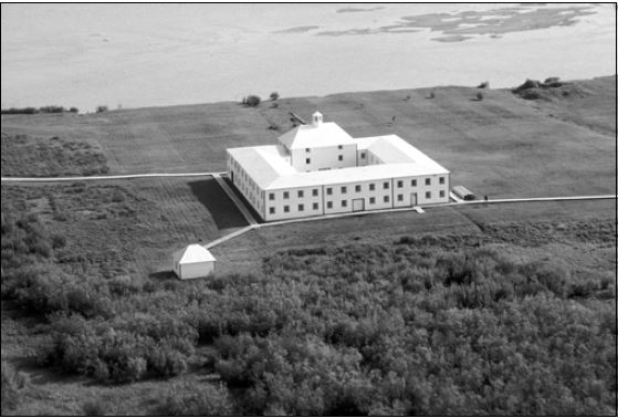 Vue aérienne d’un grand bâtiment blanc. Une rivière est visible en haut de l’image.