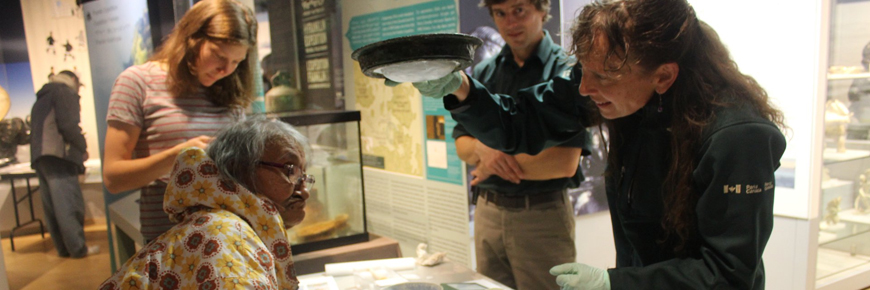 Four people interacting with an artifact.