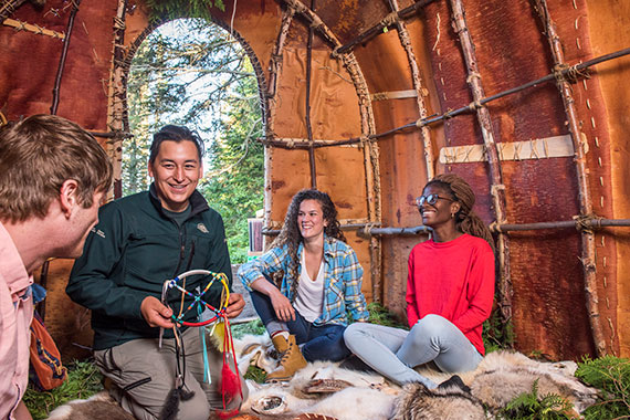 Visitors with park interpreter at Anishinaabe camp, Pukaskwa National Park.