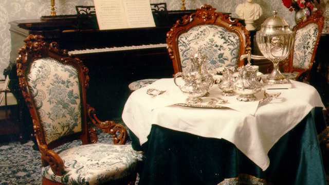 A tea service in antique silver, including a teapot, sits on the magnificent table in the blue salon at Sir-George-Étienne-Cartier National Historic Site.