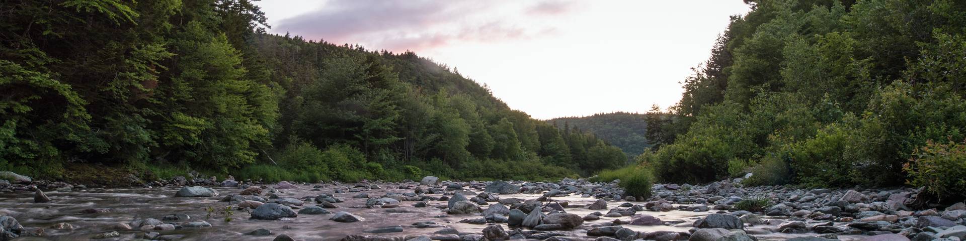 Une rivière peu profonde au coucher du soleil