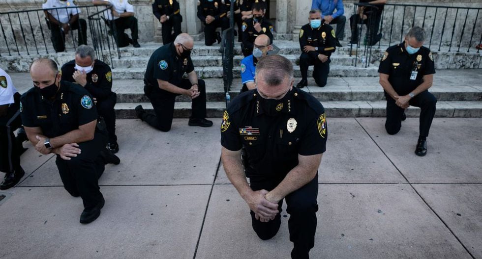 Oficiales de policía se arrodillan durante una manifestación en Coral Gables, Florida, en respuesta a la reciente muerte de George Floyd, un hombre negro desarmado que murió mientras era arrestado y sujetado al suelo por un oficial de policía de Minneapolis. (AFP / Eva Marie UZCATEGUI)
