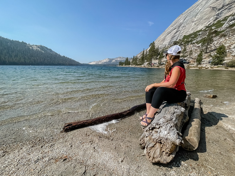 Lina Stock sitting on a log at Tenaya Lake in Yosemite