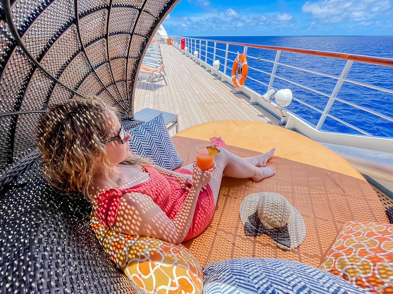 Lina Stock sitting in lounger with a tropical drink while cruising in Tahiti with Windstar Cruises
