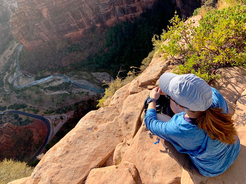Lina Stock of Divergent Travelers Adventure Travel Blog looking down from Angels Landing in Zion National Park.