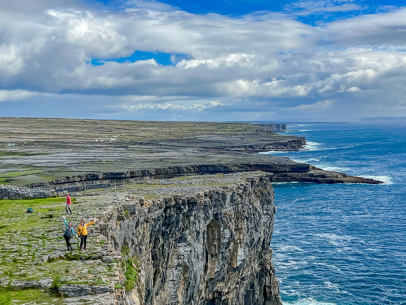 Personas de pie cerca del borde del acantilado en Inis Mor