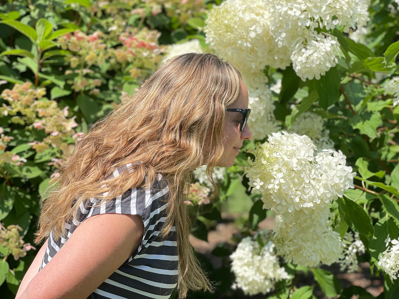 Lina Stock of Divergent Travelers Adventure Travel Blog stopping and smelling the flowers at the Allen Centennial Gardens in Madison Wisconsin.