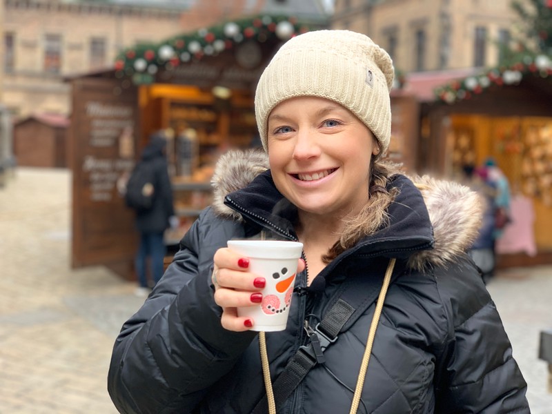 Lina Stock of Divergent Travelers Adventure Travel blog enjoying a cup of Svarak (Hot Wine) at the Prague Castle Christmas Market
