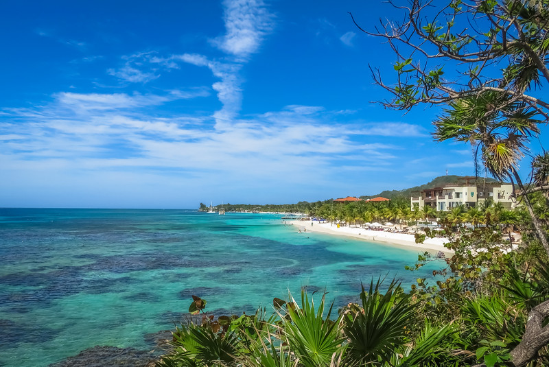 Landscape of a tropical blue ocean water and sandy beach in Roatan island.