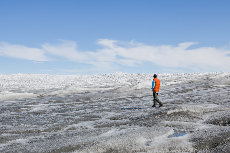 David Stock Jr of Divergent Travelers Adventure Travel Blog walking across the Russel Glacier in Greenland. 