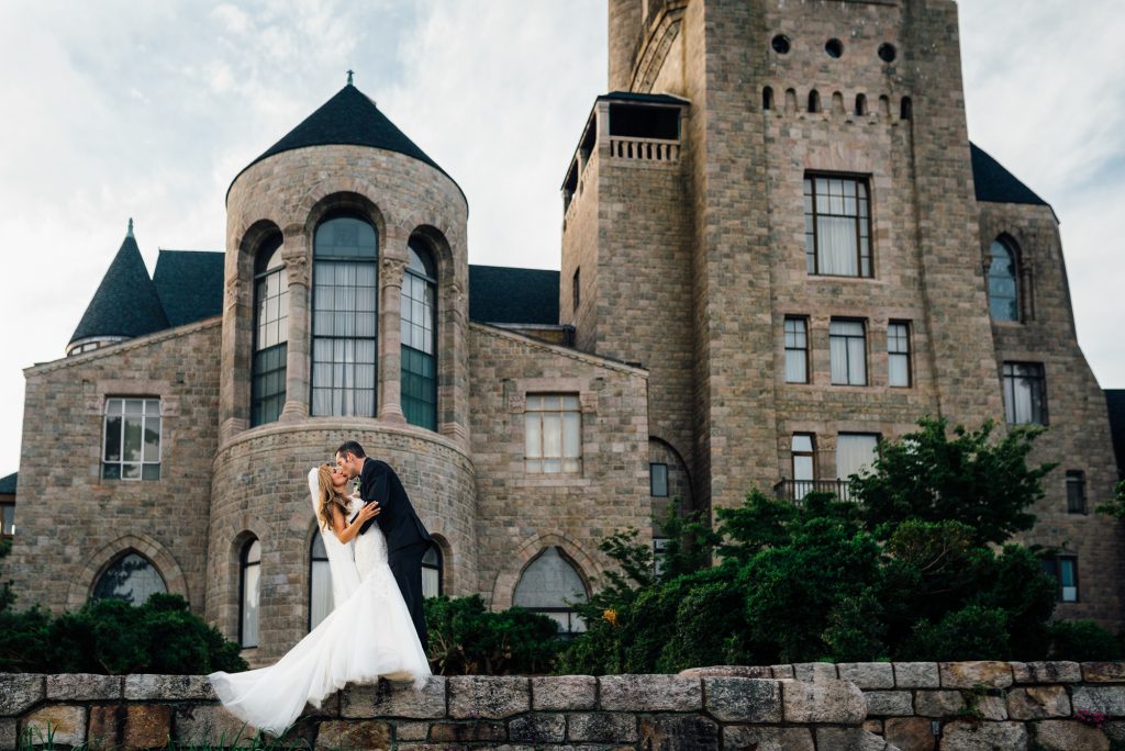 Romantic image of bride and groom kissing in front of mansion